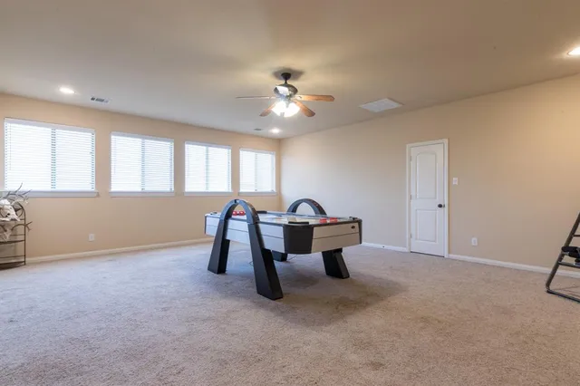 a living room with furniture and a ceiling fan