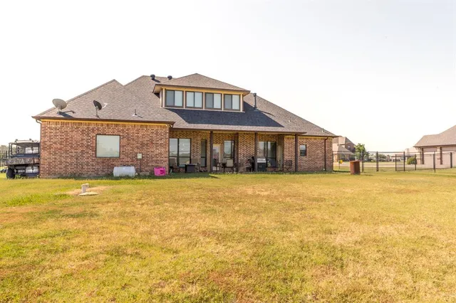 a front view of a house with a yard and swimming pool
