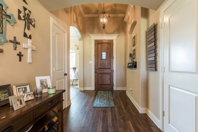 a view of a hallway with wooden floor and a bathroom