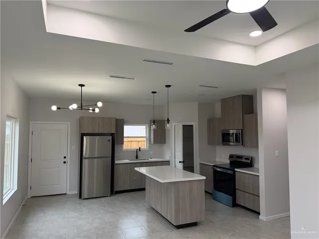 a kitchen with refrigerator a microwave and stove