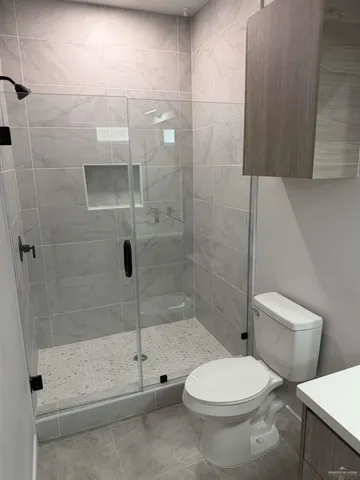 a white toilet sitting next to a bath tub and shower