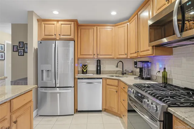 a kitchen with granite countertop a refrigerator stove top oven and sink
