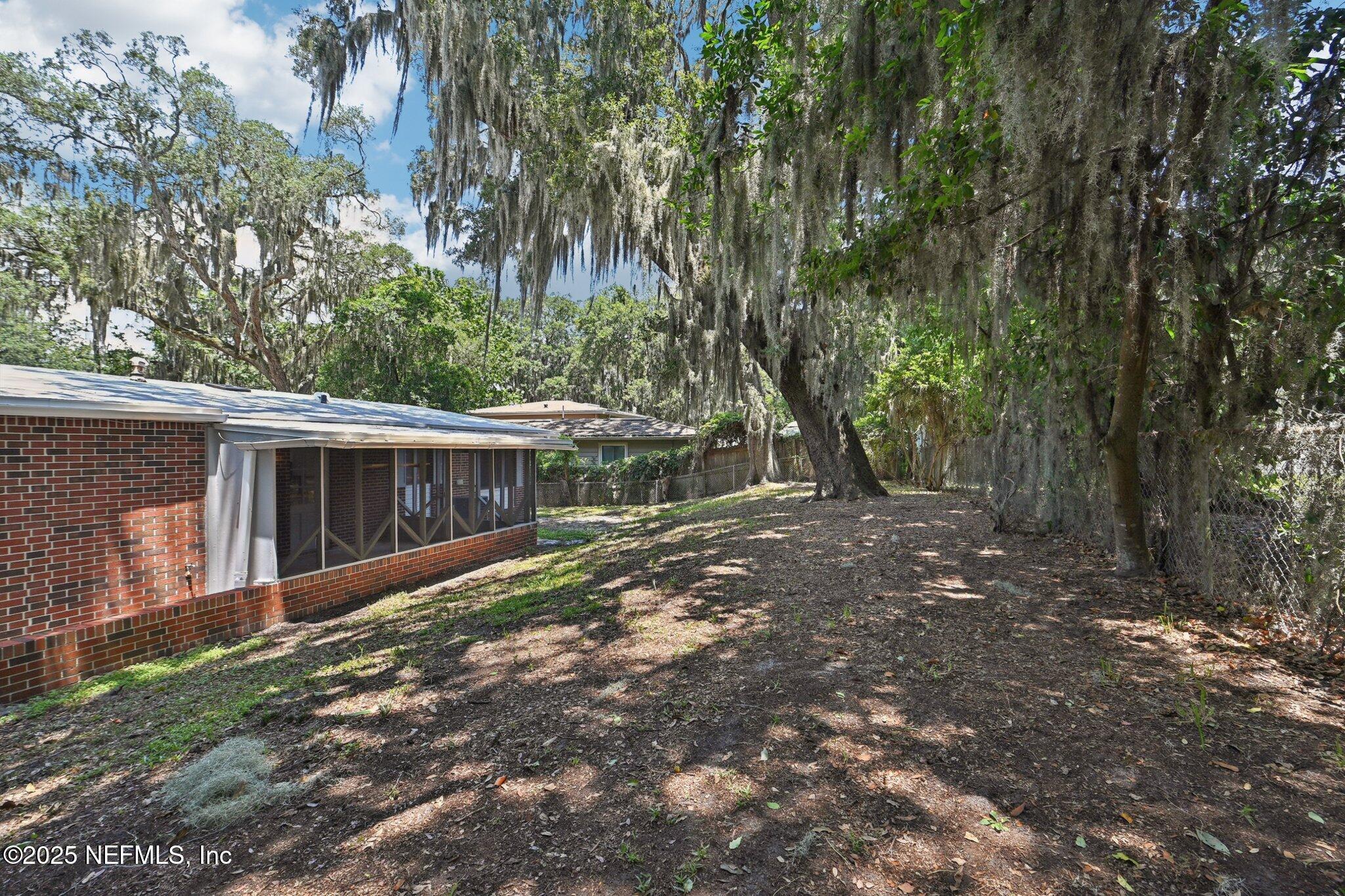 4619 Morris Road Jacksonville, FL 32225 - Photo 35 of 56 a view of a backyard with large trees and wooden fence