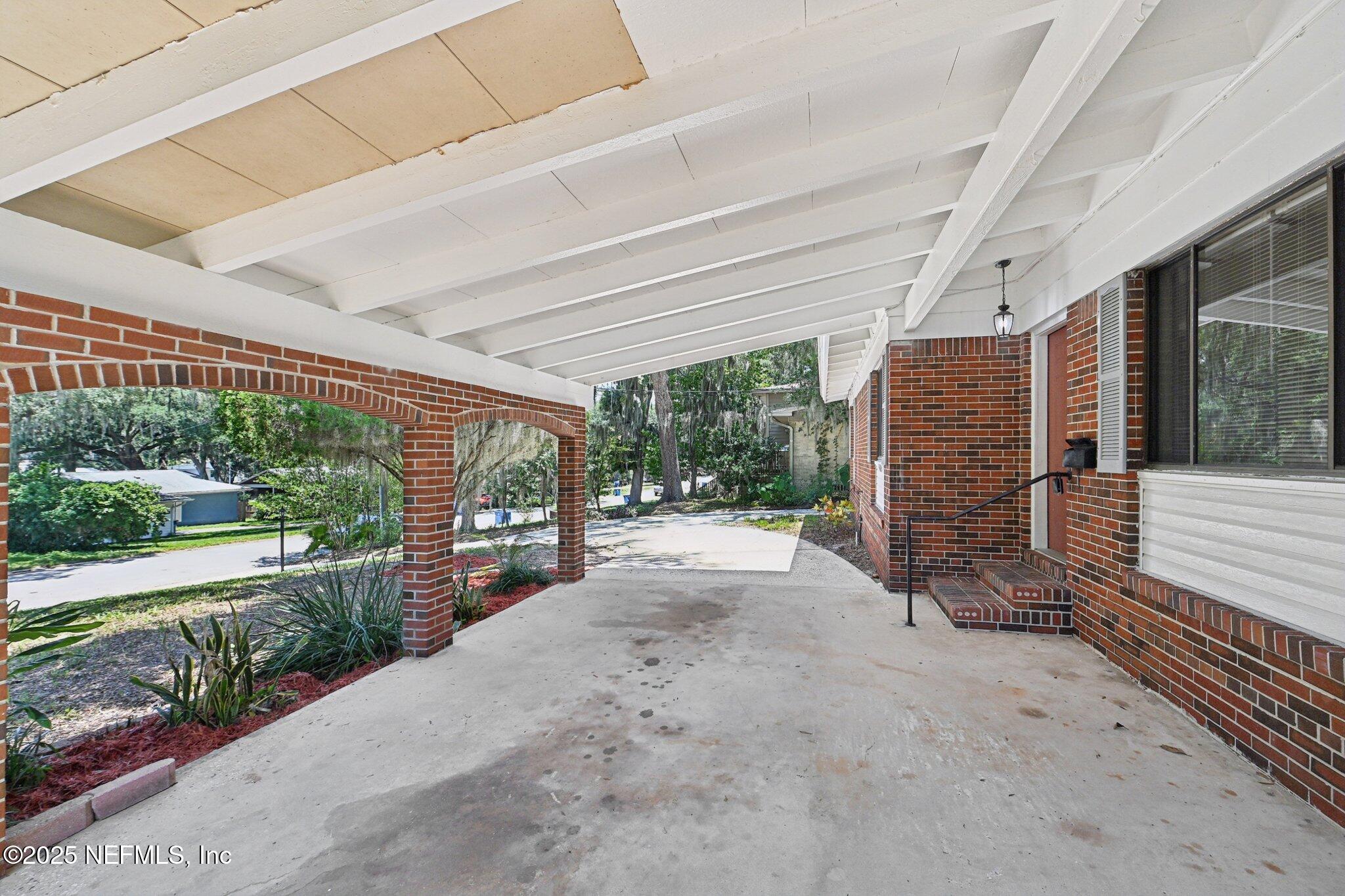 4619 Morris Road Jacksonville, FL 32225 - Photo 5 of 56 a view of a porch with wooden floor and roof with a garden view