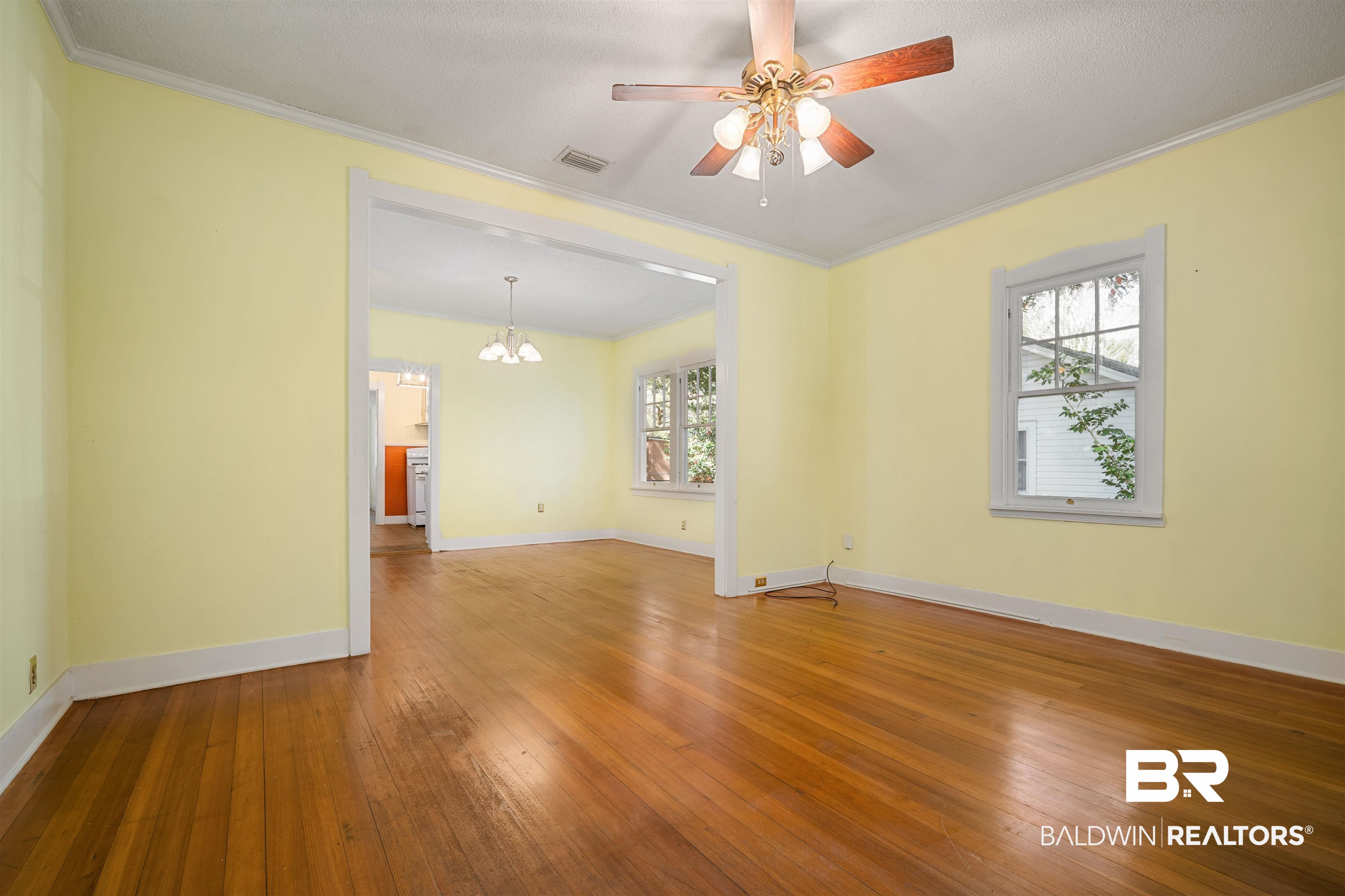 118 Mohawk Street Mobile, AL 36606 - Photo 5 of 26 Unfurnished room with hardwood / wood-style flooring, a ceiling fan, ornamental molding, and hanging lights