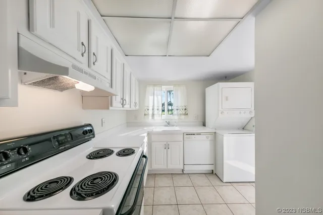 a kitchen with white cabinets and sink