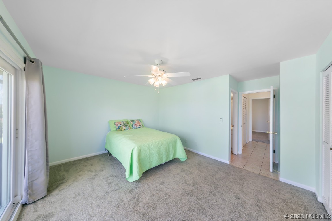 4790 South Atlantic Avenue, Unit F601 Ponce Inlet, FL 32127 - Photo 24 of 37 a bedroom with a bed and a chandelier