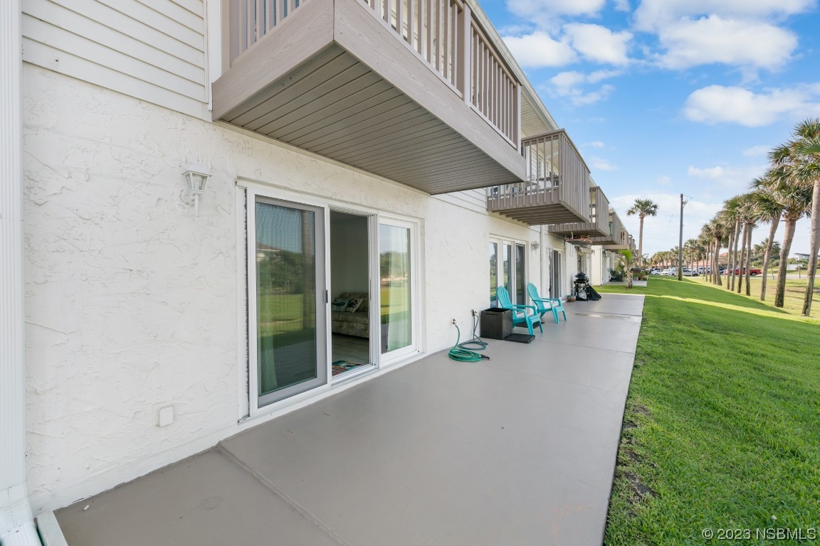4790 South Atlantic Avenue, Unit F601 Ponce Inlet, FL 32127 - Photo 10 of 37 a view of a patio with chairs and a small yard