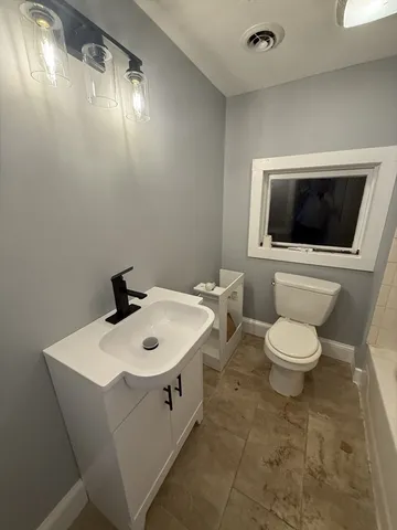 a bathroom with a toilet a sink and mirror