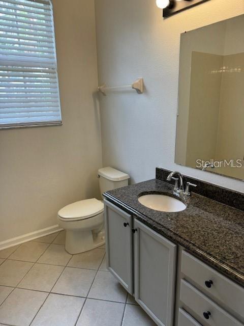 13584 Turtle Marsh Loop, Unit 132 Orlando, FL 32837 - Photo 17 of 21 a bathroom with a granite countertop toilet a sink and a mirror