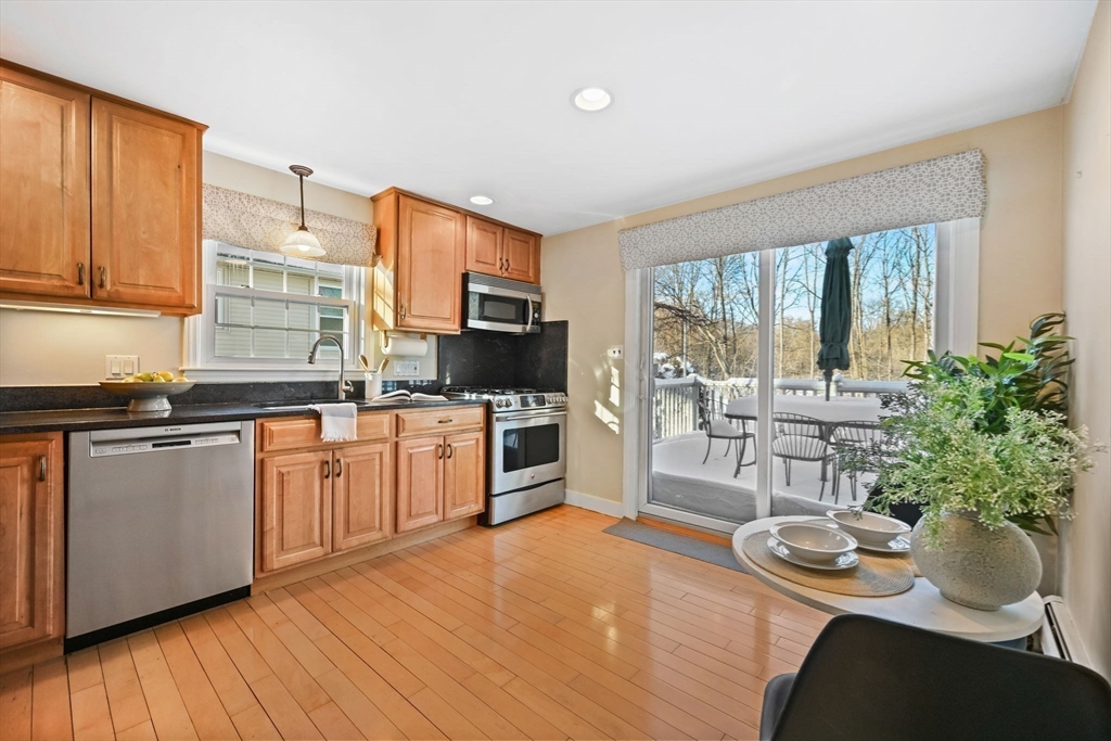 48 Grapevine Avenue Lexington, MA 02421 - Photo 13 of 34 a kitchen with stainless steel appliances a stove a sink and white cabinets with wooden floor
