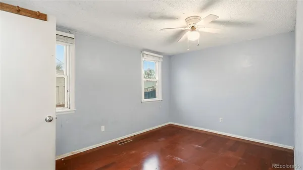 an empty room with a window and a fan