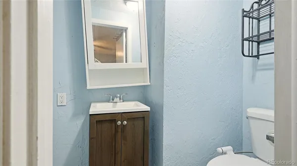 a bathroom with a sink vanity mirror and toilet