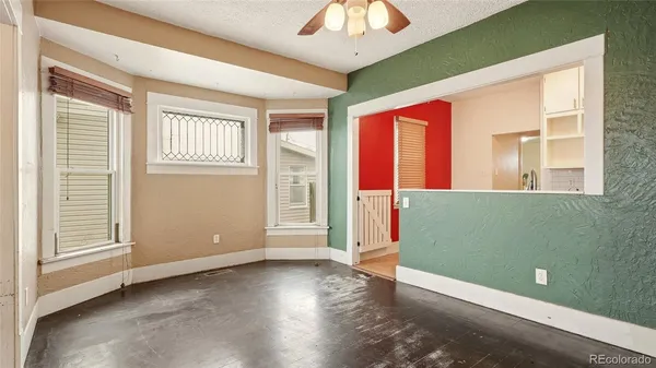 a view of an empty room with a window and wooden floor
