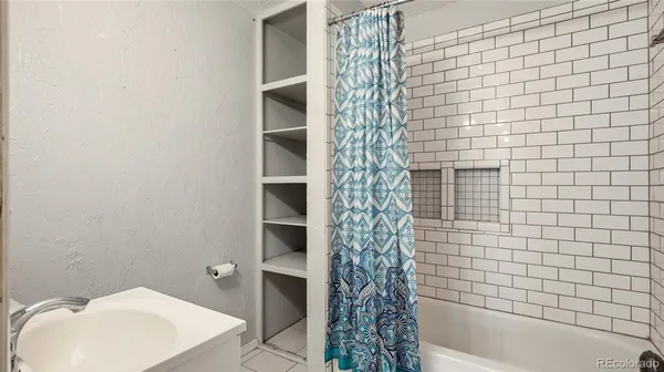 a bathroom with a white bathtub and shower