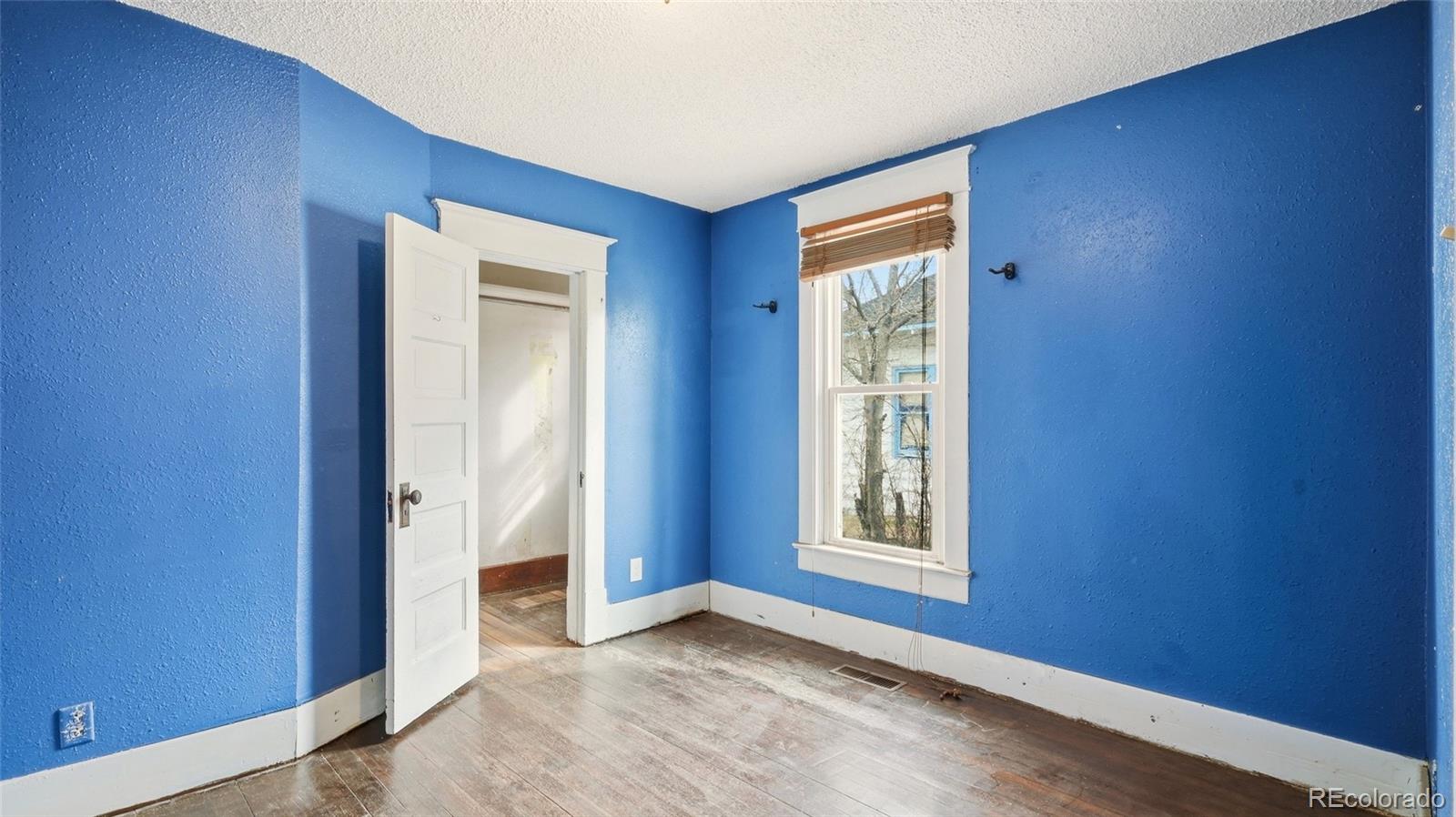 220 State Street Sterling, CO 80751 - Photo 10 of 15 a view of an empty room with window and wooden floor