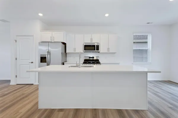 a kitchen with granite countertop white cabinets and stainless steel appliances