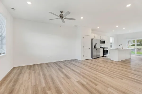 a view of empty room with wooden floor and window