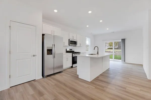 a kitchen with stainless steel appliances a refrigerator and a stove top oven