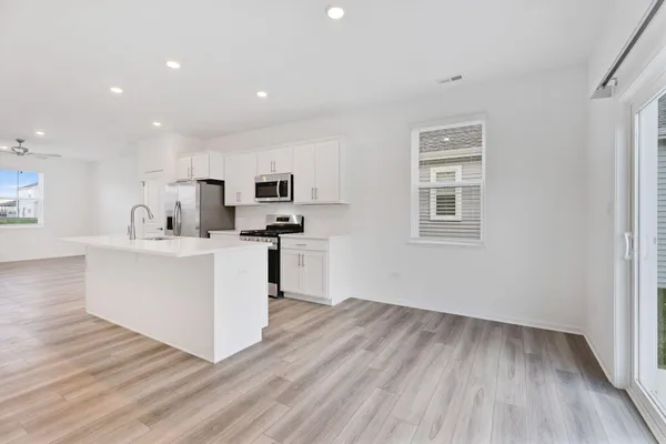 a view of kitchen with wooden floor and electronic appliances