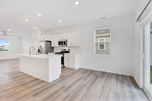 a view of kitchen with wooden floor and electronic appliances