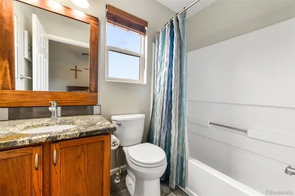 a bathroom with a granite countertop sink toilet and shower