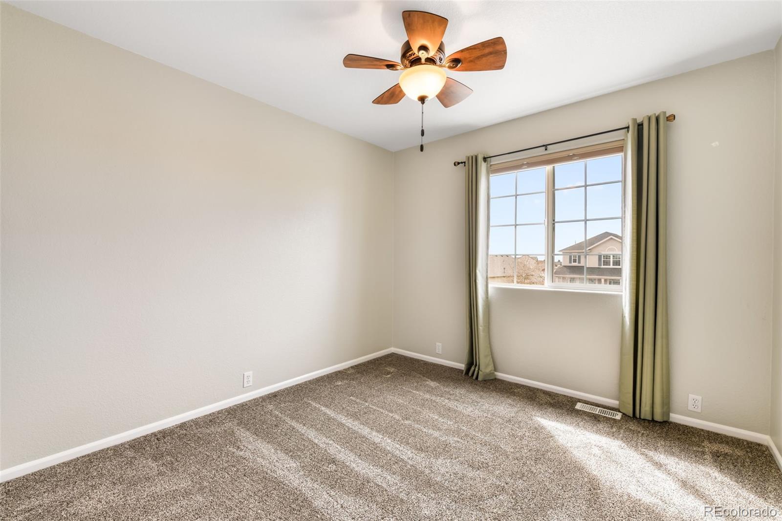 12906 Oakland Hills Road Peyton, CO 80831 - Photo 16 of 50 an empty room with a window and a ceiling fan