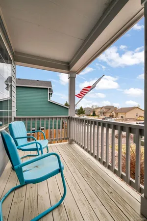 a balcony with chairs and wooden floor