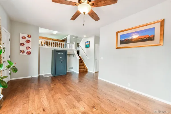 a view of a hallway with wooden floor and staircase