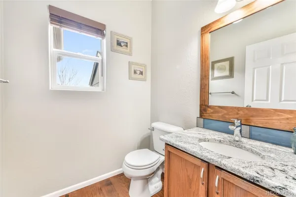 a bathroom with a granite countertop toilet sink and mirror