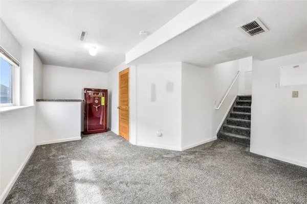 a view of an empty room with stairs and a hallway