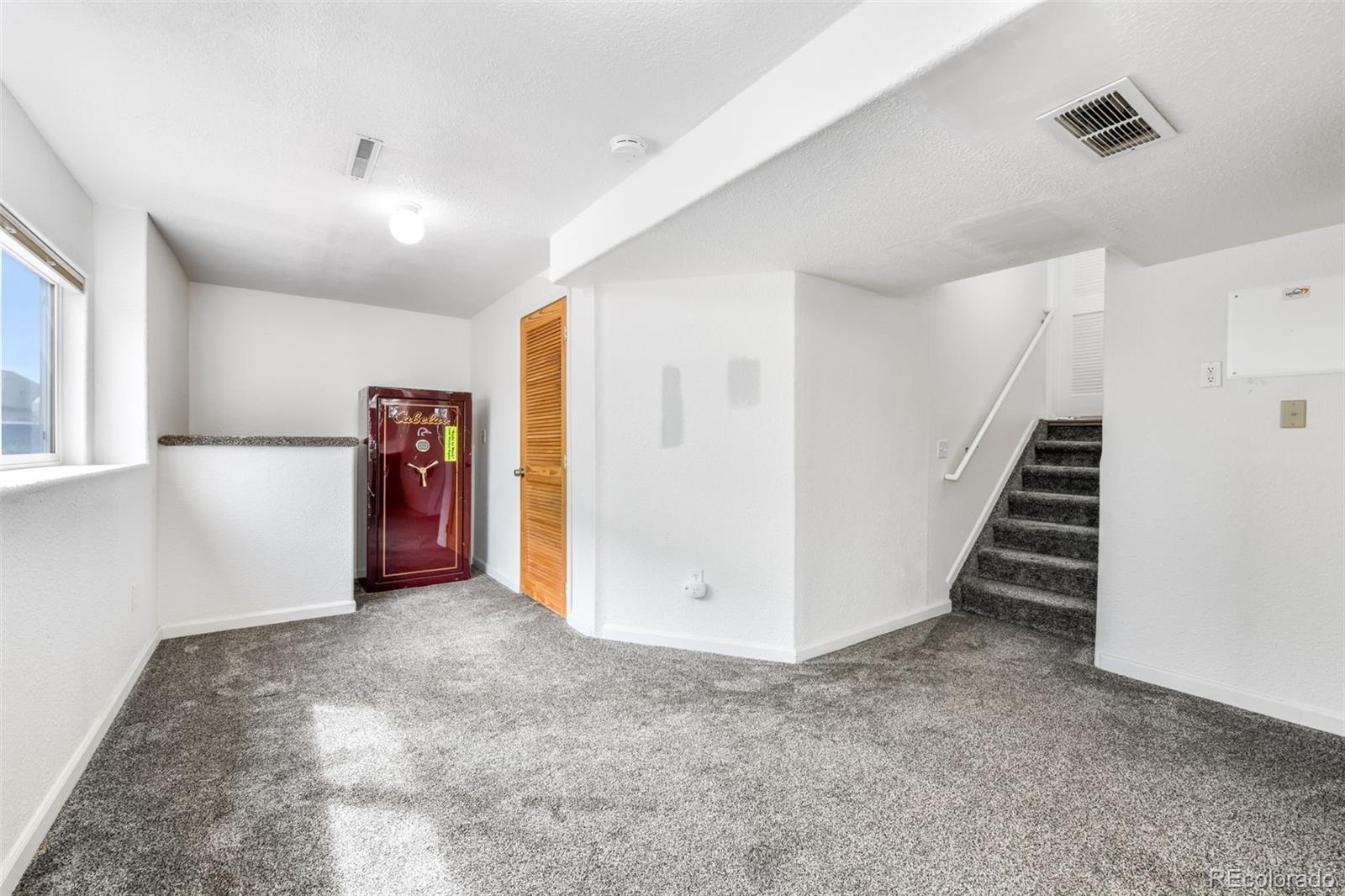 12906 Oakland Hills Road Peyton, CO 80831 - Photo 28 of 50 a view of an empty room with stairs and a hallway