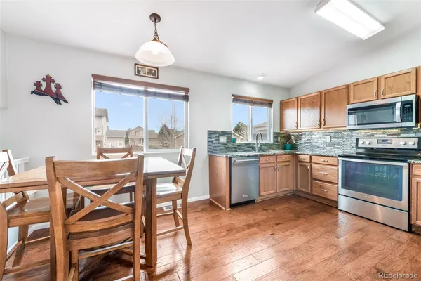 a kitchen with a table chairs a sink dishwasher window and cabinets