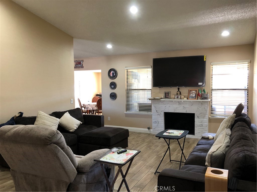 8864 Haskell Street Riverside, CA 92503 - Photo 3 of 18 a living room with furniture a flat screen tv and a fireplace