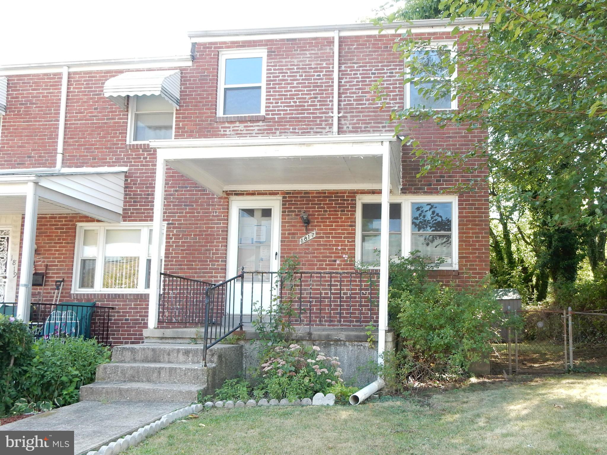 1817 Swansea Road Baltimore, MD 21239 - Photo 1 of 8 front view of a brick house with a yard