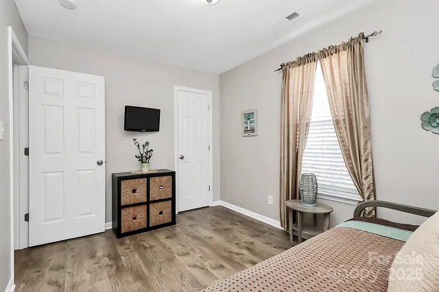 a bedroom with a bed and a flat tv screen on the dresser