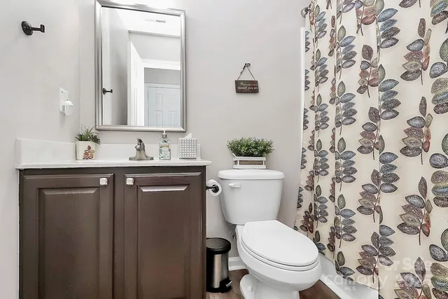 a bathroom with a granite countertop toilet sink and mirror