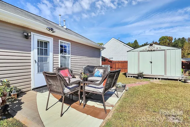 a backyard of a house with table and chairs