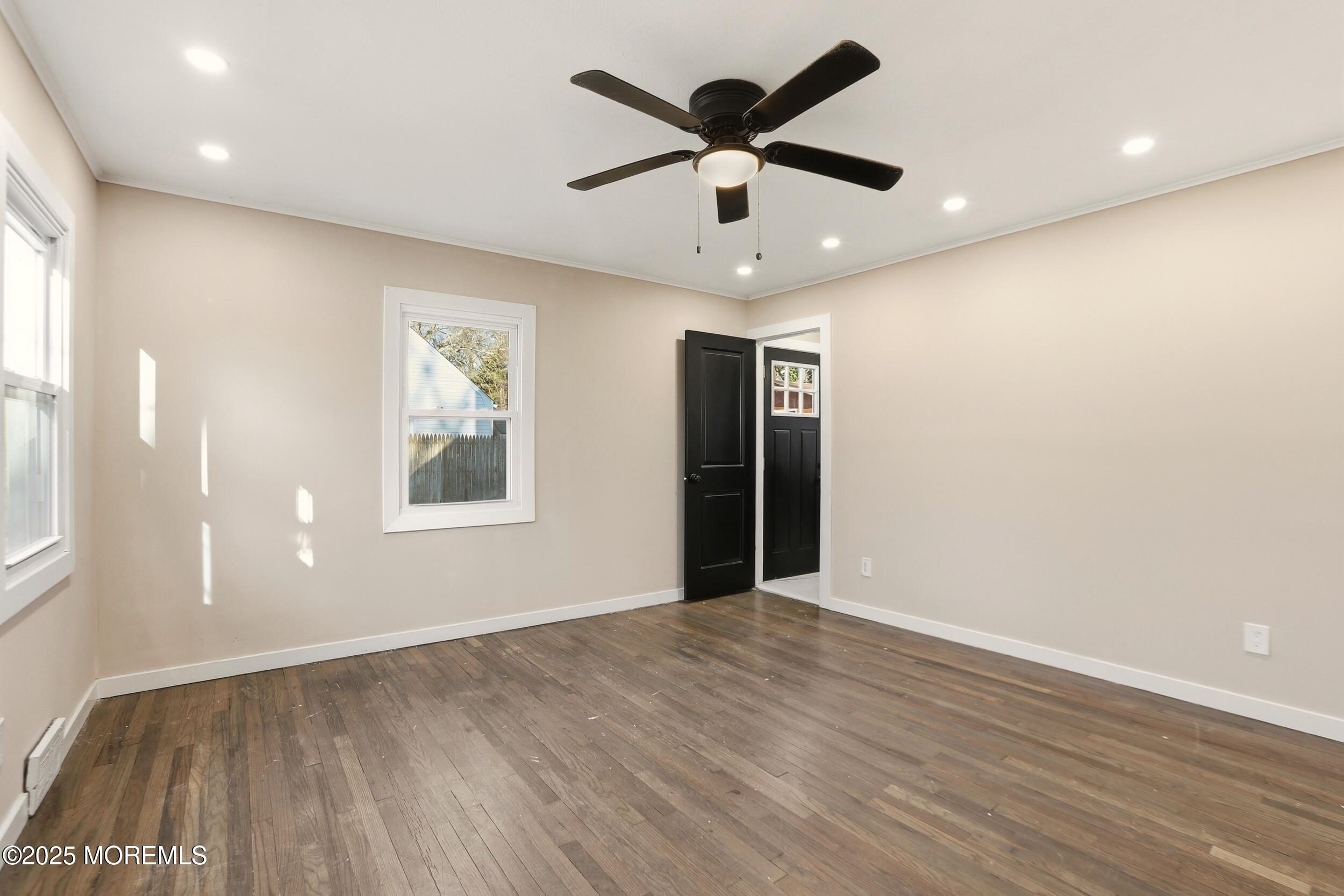 22 Oak Ridge Parkway Toms River, NJ 08755 - Photo 16 of 28 an empty room with wooden floor and windows