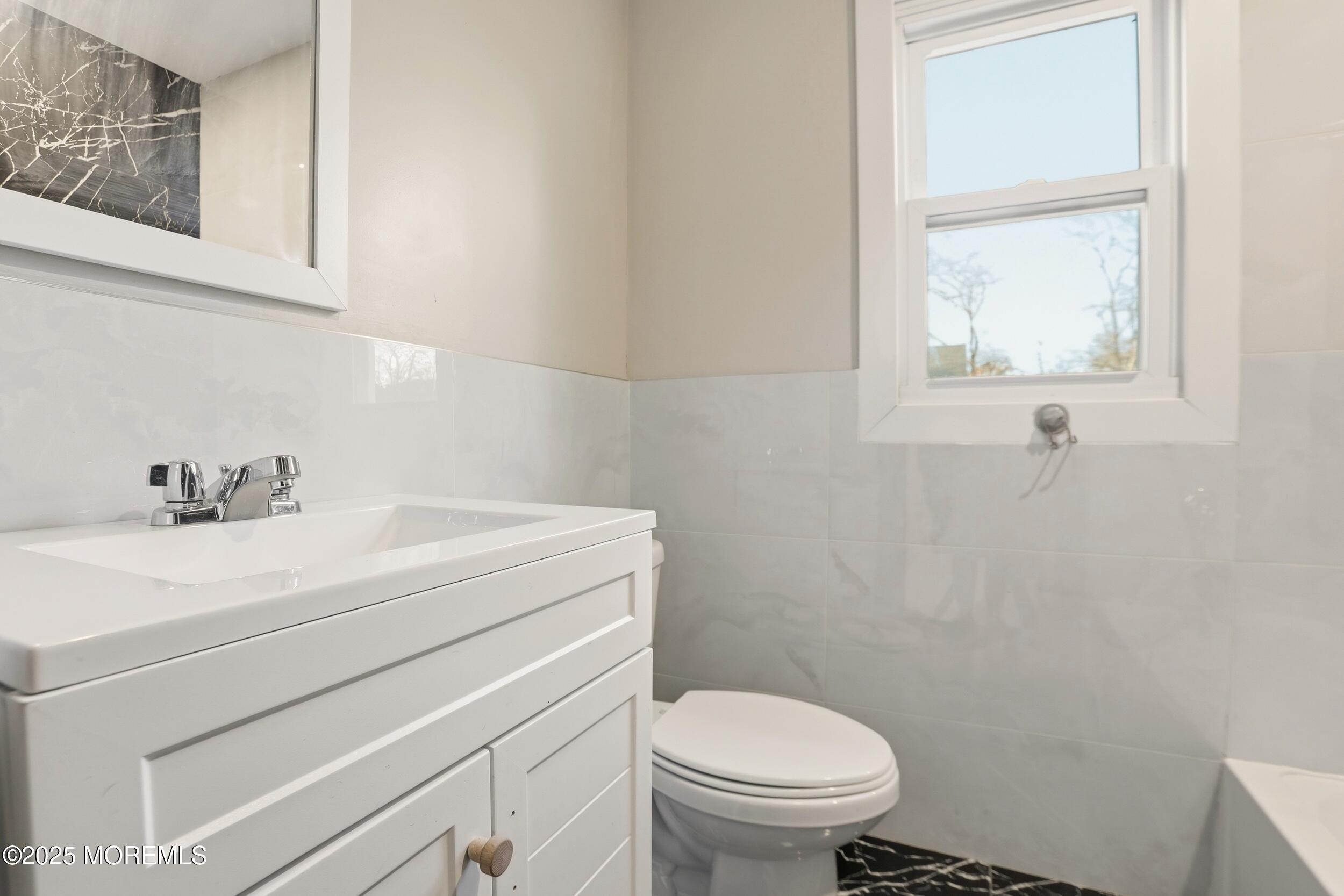 22 Oak Ridge Parkway Toms River, NJ 08755 - Photo 21 of 28 a bathroom with a sink a toilet and a window