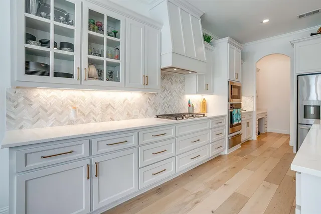 a kitchen with granite countertop white cabinets and wooden floor
