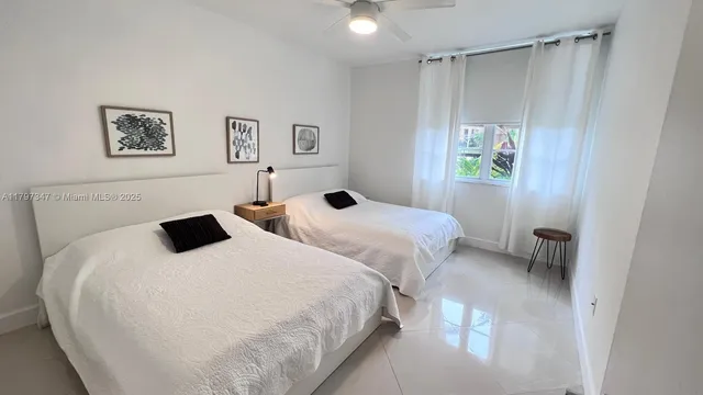 a bedroom with two beds and a window