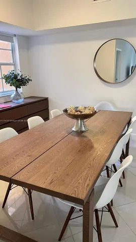 a bedroom with a table chairs and a wooden floor