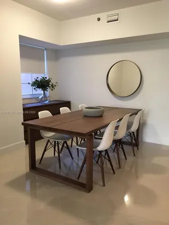 a bedroom with a table chairs and a wooden floor