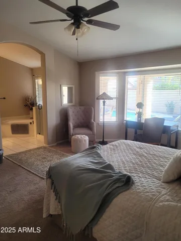 a bedroom with a large bed and a chandelier