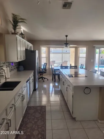 a large kitchen with stainless steel appliances granite countertop a sink counter space cabinets and a large window