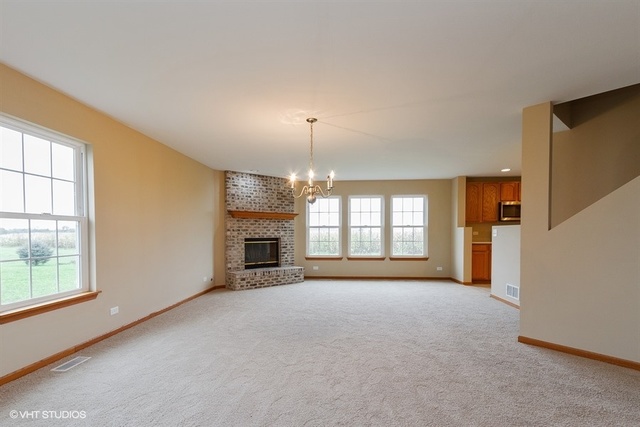 2224 Ridge Drive Hebron, IL 60034 - Photo 8 of 29 an empty room with windows and fireplace
