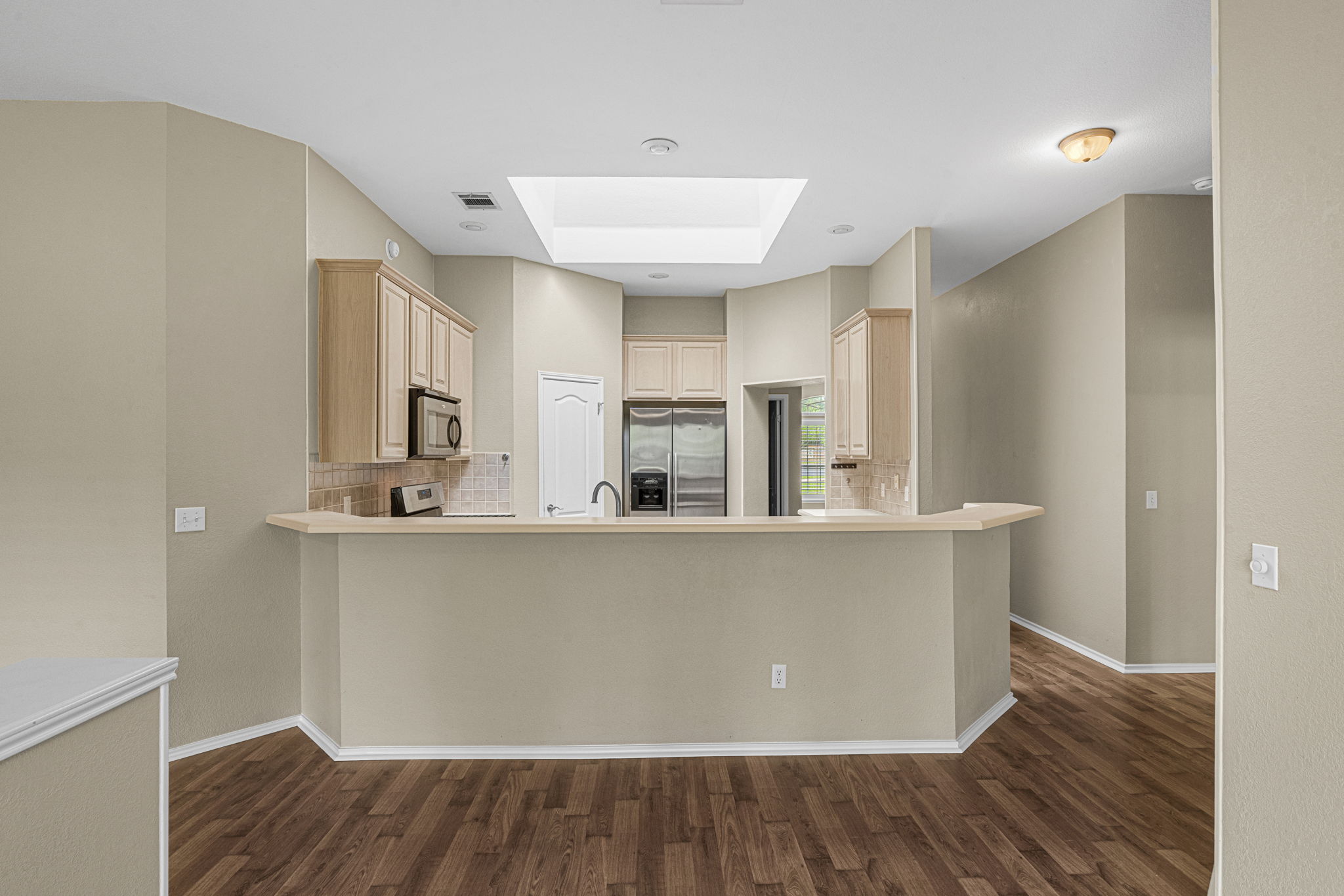7172 Ridge Oak Road Austin, TX 78749 - Photo 23 of 40 A well-lit kitchen area with modern appliances and rich hardwood flooring awaits.