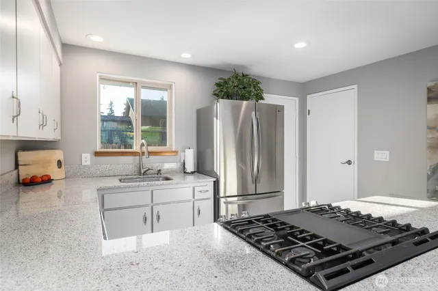 a kitchen with sink stove and refrigerator