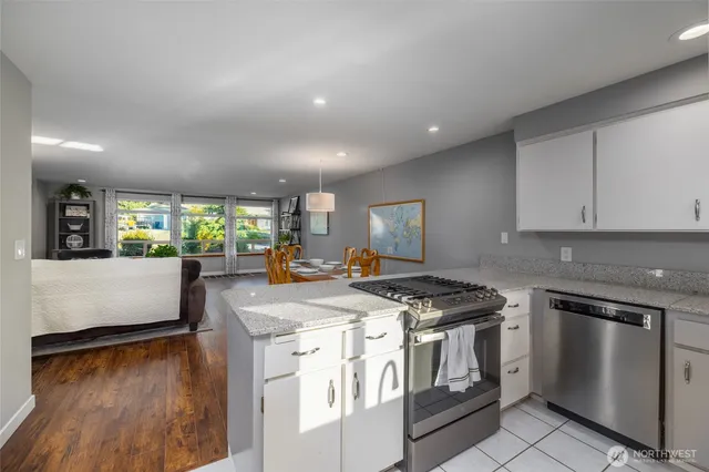 a kitchen with stainless steel appliances granite countertop a stove a sink and a refrigerator